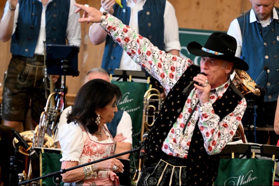 Schauspieler Wolfgang Fierek singt auf der Bühne des Schützenzelts.