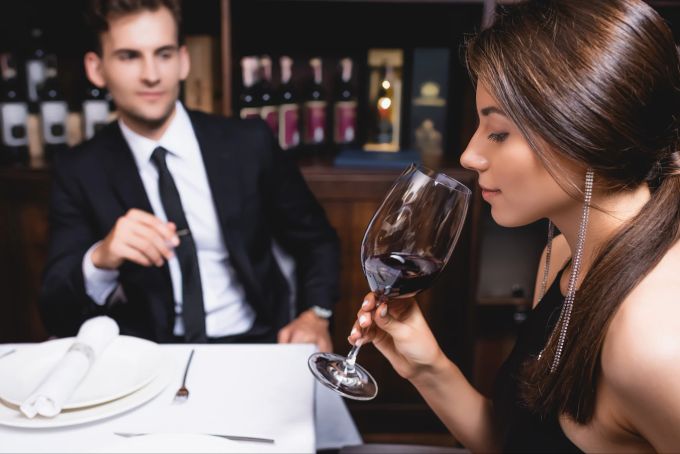 Seien Sie mit dem Alkohol vorsichtig. Wenn Sie sich beim ersten Date einen Antrinken, könnte er denken Sie trinken regelmässig zu viel. Dating, Frau trinkt Rotwein im Restaurant