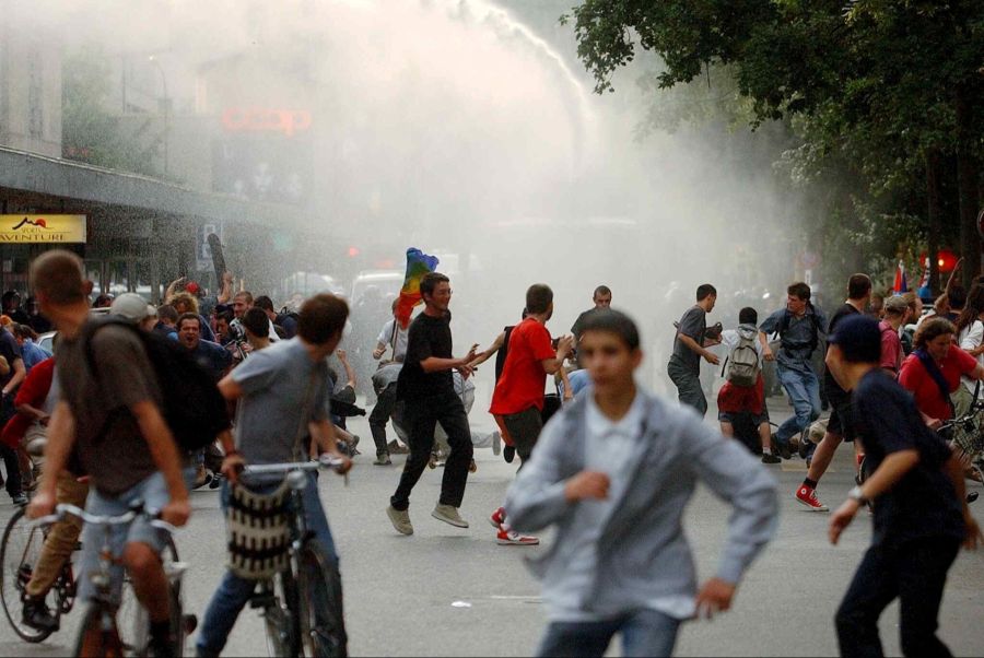 Demonstranten fliehen vor Wasserwerfern und Tränengas während Zusammenstössen mit der Polizei in Genf am Dienstag, dem 3. Juni 2003.