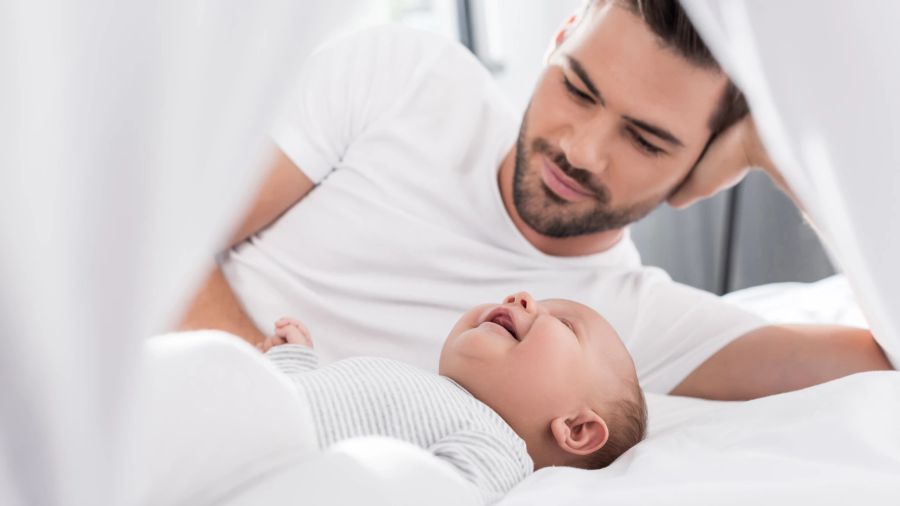 Papa mit Baby im Bett