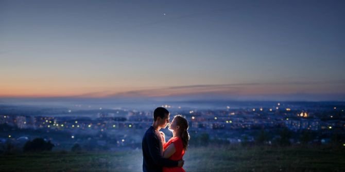 junges paar vor stadtkulisse, küssen sich