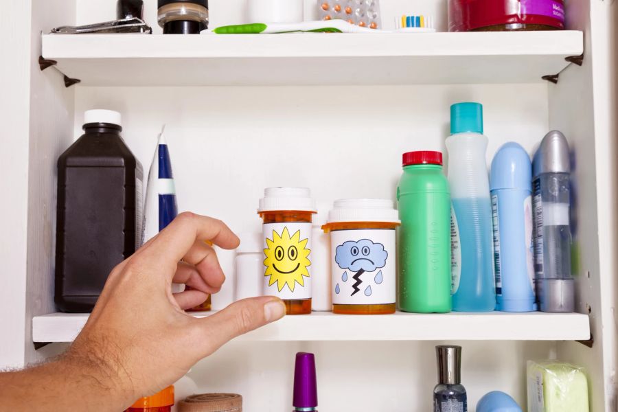 Hand greift in Medizinschrank