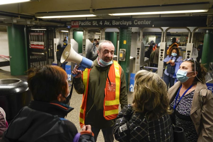 Ein Mitarbeiter der New Yorker U-Bahn informiert Passagiere über den Vorfall.