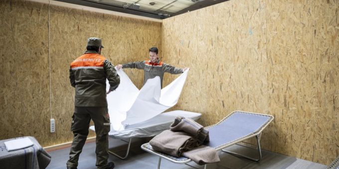 Zivilschützer helfen beim Aufbau von Betten und Trennwänden in der Saalsporthalle für die kurzfristige Unterbringung von Geflüchteten aus der Ukraine, aufgenommen am Dienstag, 22. März 2022 in Zürich. Zivilschutz Flüchtlinge Ukraine Krieg