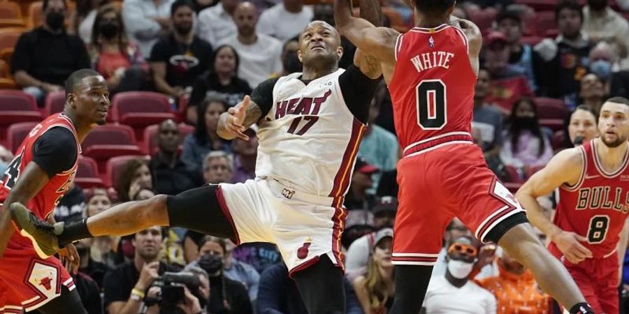 P.J. Tucker (M, l) von Miami Heat und Coby White von Chicago Bulls kämpfen in der ersten Halbzeit um dem Ball. Foto: Marta Lavandier/AP/dpa