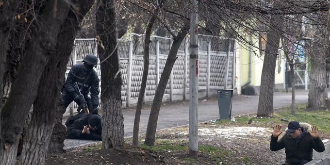 Ein bewaffneter Bereitschaftspolizist hält zwei Demonstranten während einer sogenannten Anti-Terror-Operation in einer Strasse in Almaty, Kasachstan, fest. Foto: Vasily Krestyaninov/AP/dpa kasachstan.
