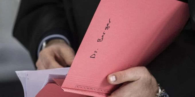 Ein Rechtsanwalt des Hauptbeschuldigten Hanno Berger hält vor dem Prozessauftakt um «Cum-Ex»-Aktiendeals im Gerichtssaal eine Akte mit der Aufschrift «Dr. Berger» in der Hand. Foto: Boris Roessler/dpa Ein Rechtsanwalt des Hauptbeschuldigten Hanno Berger hält vor dem Prozessauftakt um «Cum-Ex»-Aktiendeals im Gerichtssaal eine Akte mit der Aufschrift «Dr. Berger» in der Hand. Foto: Boris Roessler/dpa
