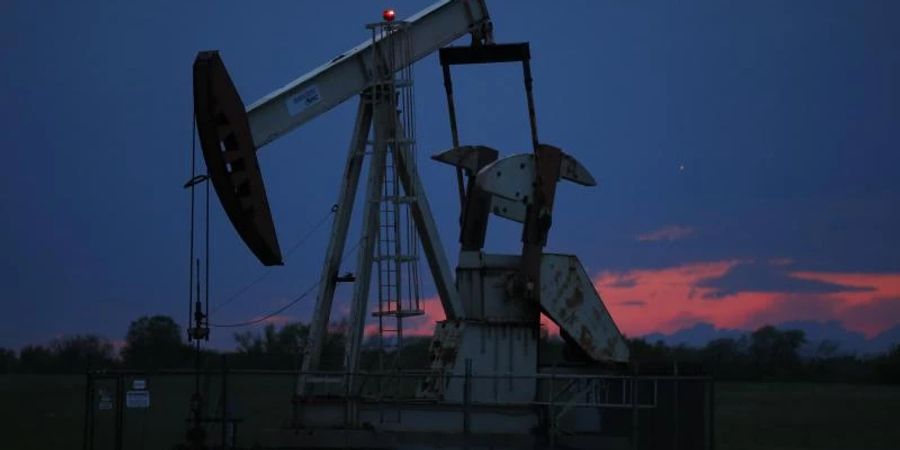 Ein Pumpe arbeitet bei Sonnenuntergang in einem Ölfeld. Der Höhenflug der Ölpreise hält an. Am Montagmorgen markierten die beiden wichtigsten Erdölsorten abermals mehrjährige Höchststände. Foto: Sue Ogrocki/AP/dpa