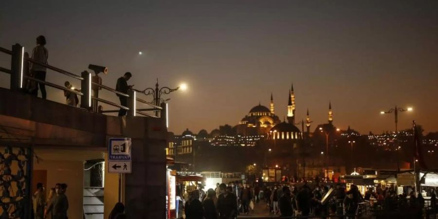 Menschen schlendern vor der Kulisse der Süleymaniye-Moschee am Ufer des Bosporus entlang. Die Zahl der Corona-Fälle in der Türkei steigt weiter an. Foto: Emrah Gurel/AP/dpa
