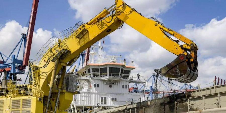 Ein Bagger holt bei Arbeiten zur Elbvertiefung Schlick aus einem Hafenbecken in Hamburg. Foto: Axel Heimken/dpa