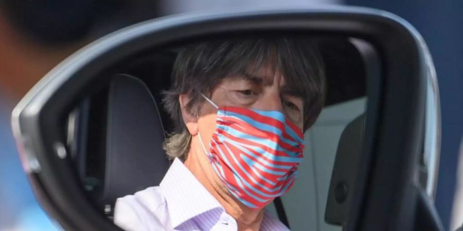 Hält sich an die Hygiene-Regeln und trägt sogar am Steuer einen Nase-Mund-Schutz: Bundestrainer Joachim Löw im Rückspiegel seines Wagens. Foto: Robert Michael/dpa-Zentralbild/dpa
