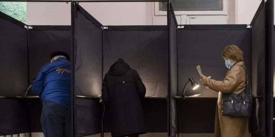 Bürger geben in einem Wahllokal in Vilnius ihre Stimme ab. Foto: Mindaugas Kulbis/AP/dpa