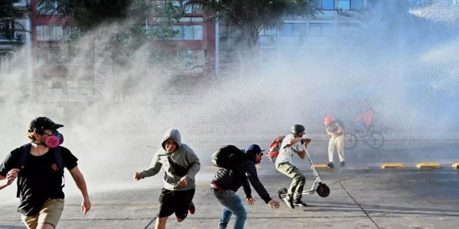 Demonstranten flüchten vor Wasserwerfern in Santiago de Chile