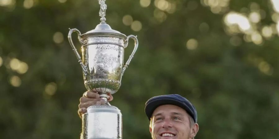 Der muskulöse Golfer Bryson DeChambeau aus den USA hält nach dem Sieg der US Open seine Trophäe in die Höhe. Foto: John Minchillo/AP/dpa