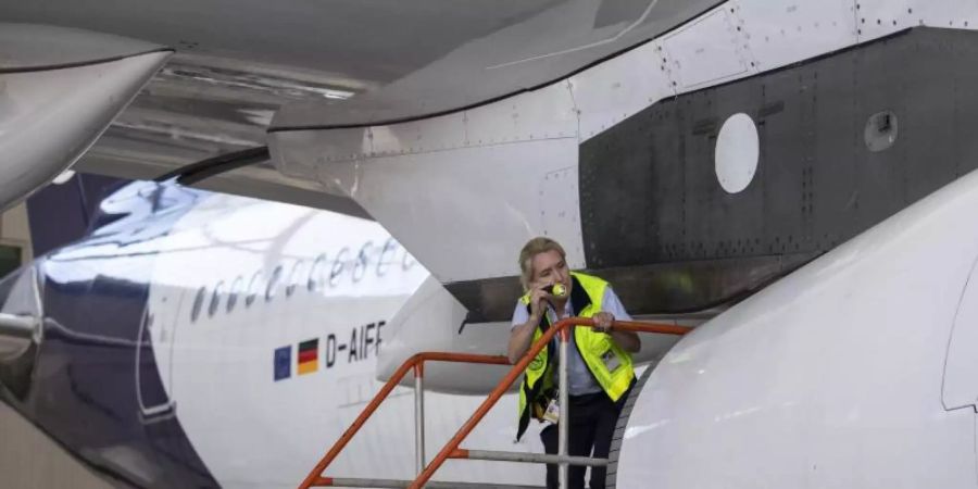 Eine Technikerin der Lufthansa inspiziert das Äussere einer Passagiermaschine der Lufthansa im Hangar der Airline auf dem Flughafen Frankfurt. Foto: Boris Roessler/dpa