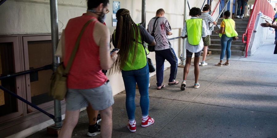 Menschen stehen in einer Schlange vor einer Affenpocken-Impfstelle im Stadtbezirk Brooklyn.