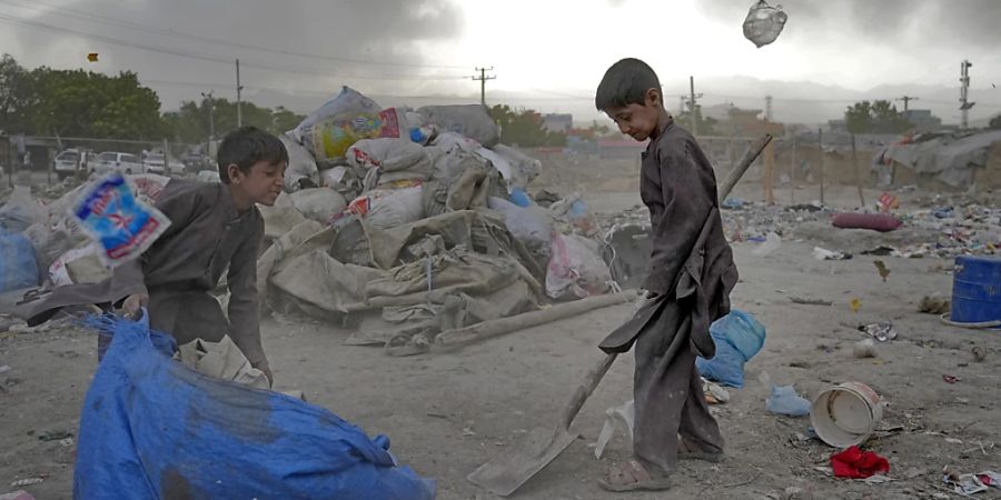 ARCHIV - Zwei afghanische Kinder sammeln in Kabul wiederverwertbares Material von einer Müllhalde. Foto: Ebrahim Noroozi/AP/dpa