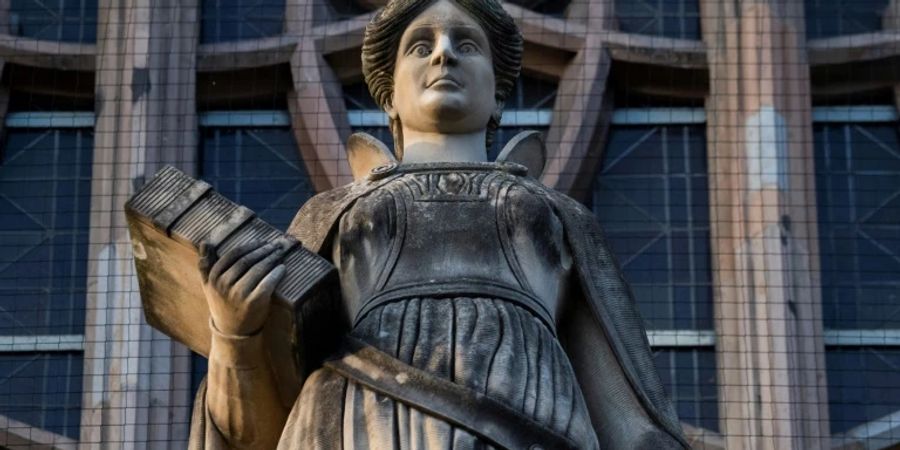 Figur an einem Gerichtsgebäude repräsentiert die Justiz