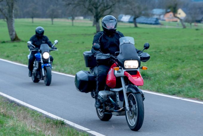 Wer mit dem Motorrad verreisen will, sollte auf gleichmäßiges Beladen der Maschine achten. Landstrasse Motorrad Feld Motorradfahrer