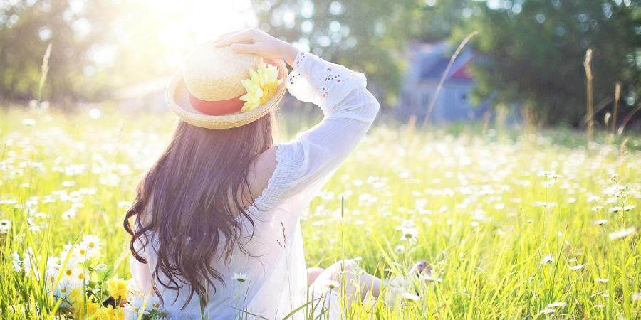 Ein Mädchen sitzt im Gras