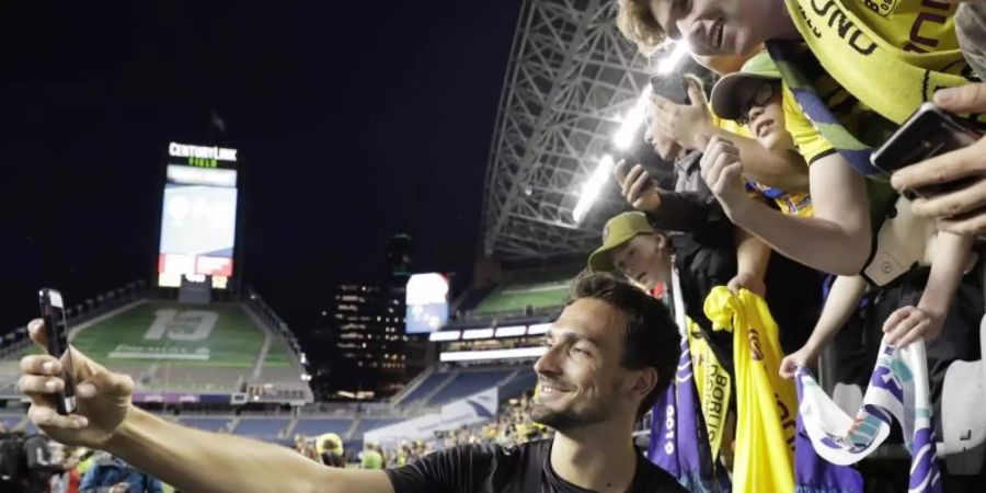 Mats Hummels fotografiert sich mit Fans von Borussia Dortmund. Foto: Ted S. Warren/AP