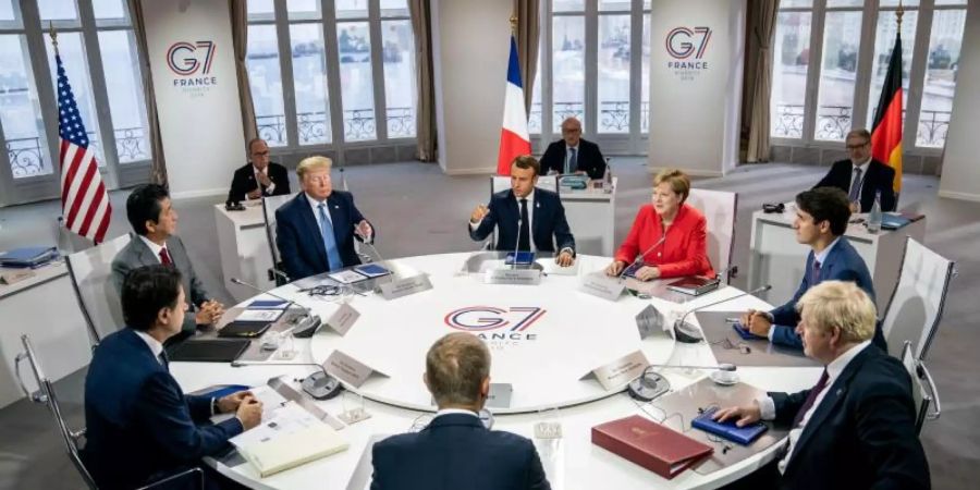 Die G7-Vertreter tagen in Biarritz: Emanuel Macron (Frankreich, M hinten), daneben im Uhrzeigersinn Bundeskanzlerin Angela Merkel, Justin Trudeau (Kanada), Boris Johnson (Grossbritannien), EU-Ratspräsident Donald Tusk, Giuseppe Conte (Italien), Shinzo Abe (Japan) und Donald Trump (USA). Foto: Michael Kappeler