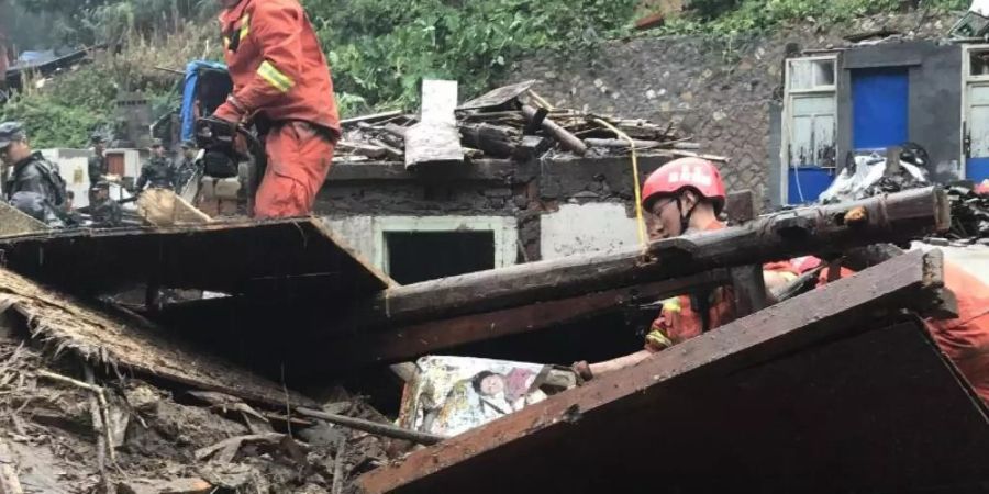 Einsatzkräfte sind in den Trümmern eines eingestürzten Gebäudes im Einsatz. Foto: Zhao Yong/XinHua