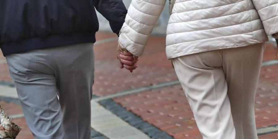 Ein älteres Paar Hand in Hand in einer Fussgängerzone. Foto: Karl-Josef Hildenbrand
