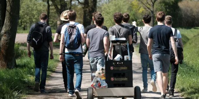 Junge Männer feiern Vatertag mit Bier und Bollerwagen Junge Männer feiern Vatertag mit Bier und Bollerwagen