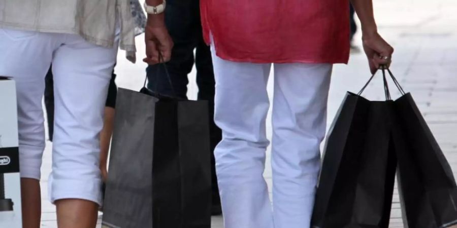 Passanten mit Einkaufstüten in einer Fussgängerzone. Die Deutschen bleiben in Kauflaune. Foto: Bodo Marks
