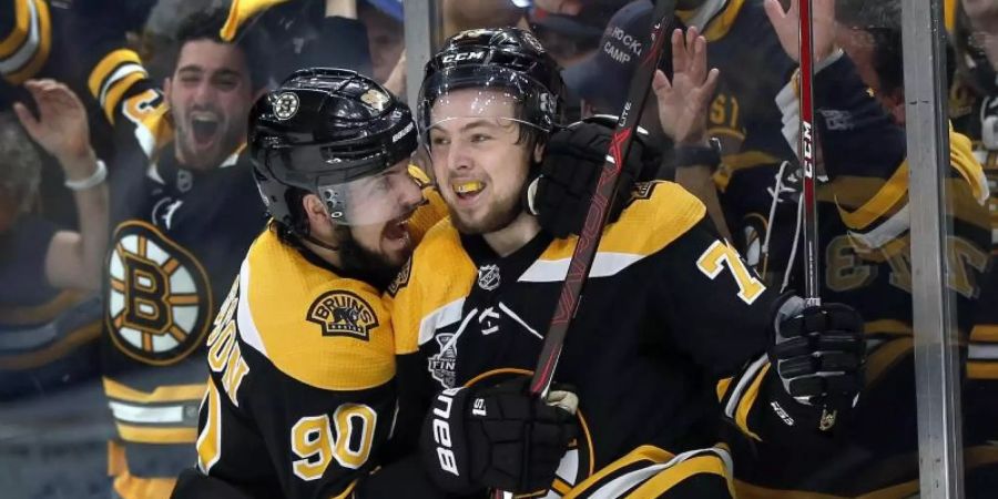 Marcus Johansson (l) und Charlie McAvoy von den Boston Bruins feiern den Sieg gegen die St. Louis Blues. Foto: Michael Dwyer/AP/dpa