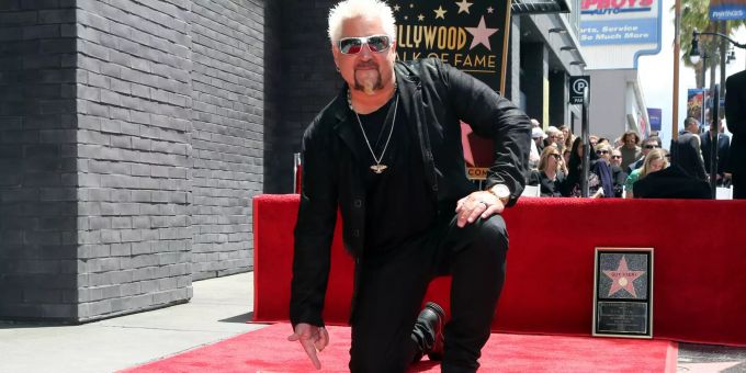 22.05.2019, USA, Los Angeles: Star-Koch und TV-Show-Moderator Guy Fieri kniet neben seinem Stern auf dem «Walk of Fame». Guy Fieri erhält Stern auf «Walk of Fame»