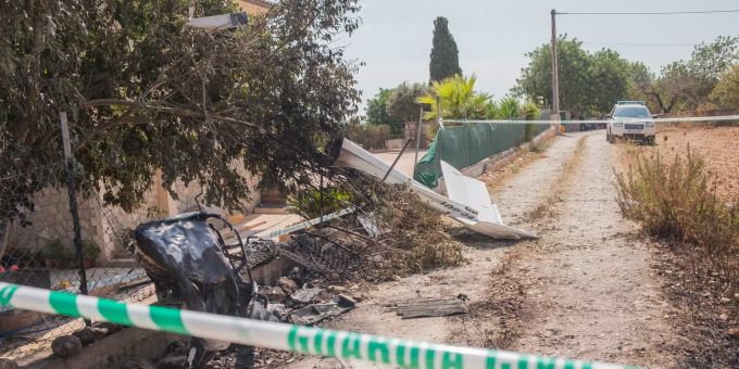 Wrackteile liegen nach der Kollision eines Ultraleichtflugzeugs mit einem Hubschrauber in der Nähe der Absturzstelle hinter Absperrband. mallorca hubschrauber