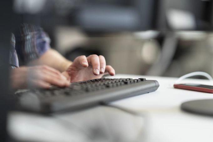 Eine Person arbeitet in einem Büro am Computer. büro schweiz