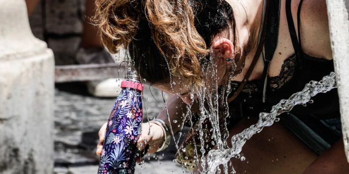 Eine Frau in Sizilien kühlt sich mit der Trinkflasche ab. (Archivbild) sizilien