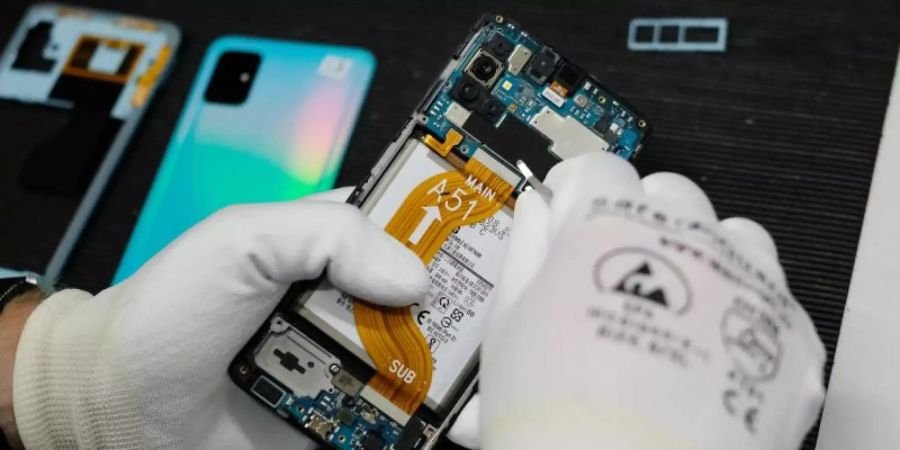 Reparatur eines Mobiltelefones in der Werkstatt der Komsa AG. Das Konsumverhalten vieler Verbraucher hat sich geändert. Das Interesse an Refurbished-Produkten ist enorm gestiegen. Foto: Sebastian Willnow/dpa-Zentralbild/dpa