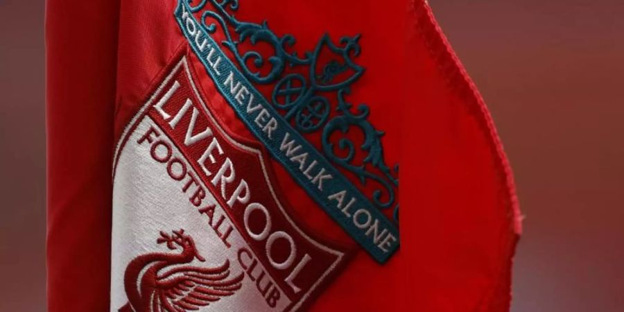 Das Wappen vom FC Liverpool mit der Aufschrift «You'll Never Walk Alone» ist auf einer Fahne zu sehen. Foto: Cath Ivill/Pool Reuters/AP/dpa