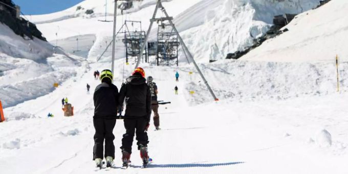Zwei Skifahrer auf einem Lift. skifahren coronavirus