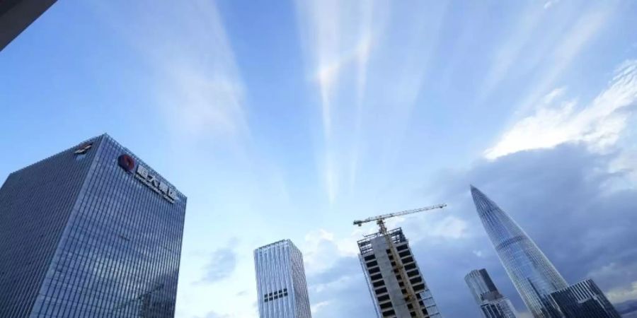 Der Hauptsitz von Evergrande (l). Die schwere Immobilienkrise in China erfasst neben dem hoch verschuldeten Evergrande-Konzern auch andere Unternehmen. Foto: Ng Han Guan/AP/dpa