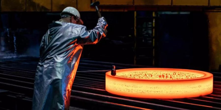 Ein glühender Rohling wird im ThyssenKrupp Werk Rothe gestempelt. Foto: Marcel Kusch/dpa