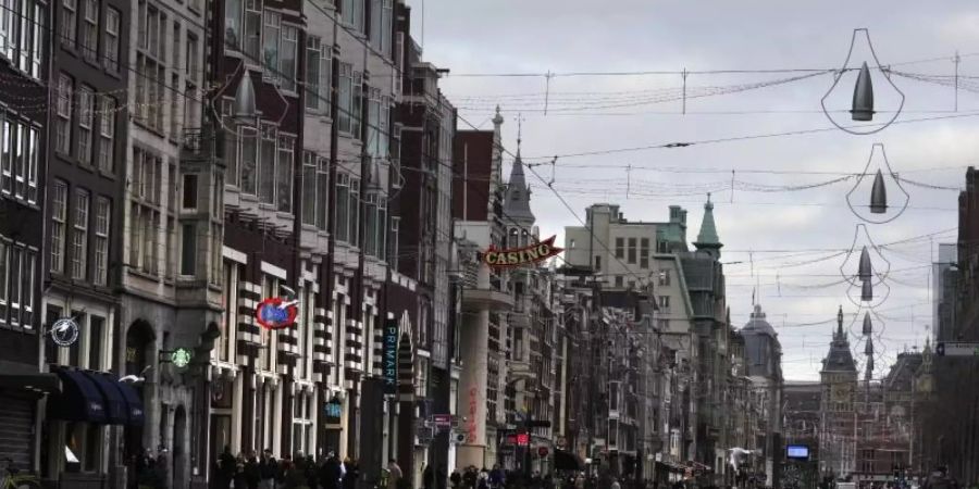 Eine fast menschenleere Strasse in Amsterdam. In den Niederlanden gilt bis mindestens 14. Januar ein harter Lockdown. Foto: Peter Dejong/AP/dpa