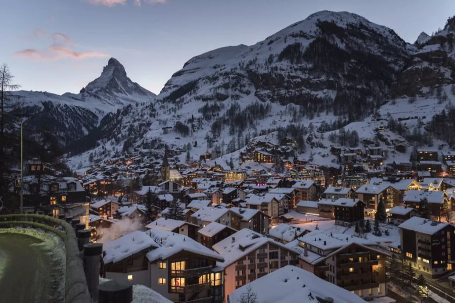 Blick auf Zermatt VS mit dem Matterhorn im Hintergrund an einem Winterabend.