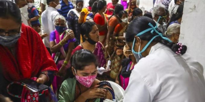 Eine Mitarbeiterin des Gesundheitswesens verabreicht eine Dosis mit dem Corona-Impfstoff Covaxin, während Hunderte von Menschen anstehen, um ihre zweite Dosis des Impfstoffs im städtischen Stadion in Hyderabad zu erhalten. Foto: Mahesh Kumar A/AP/dpa Eine Mitarbeiterin des Gesundheitswesens verabreicht eine Dosis mit dem Corona-Impfstoff Covaxin, während Hunderte von Menschen anstehen, um ihre zweite Dosis des Impfstoffs im städtischen Stadion in Hyderabad zu erhalten. Foto: Mahesh Kumar A/AP/dpa