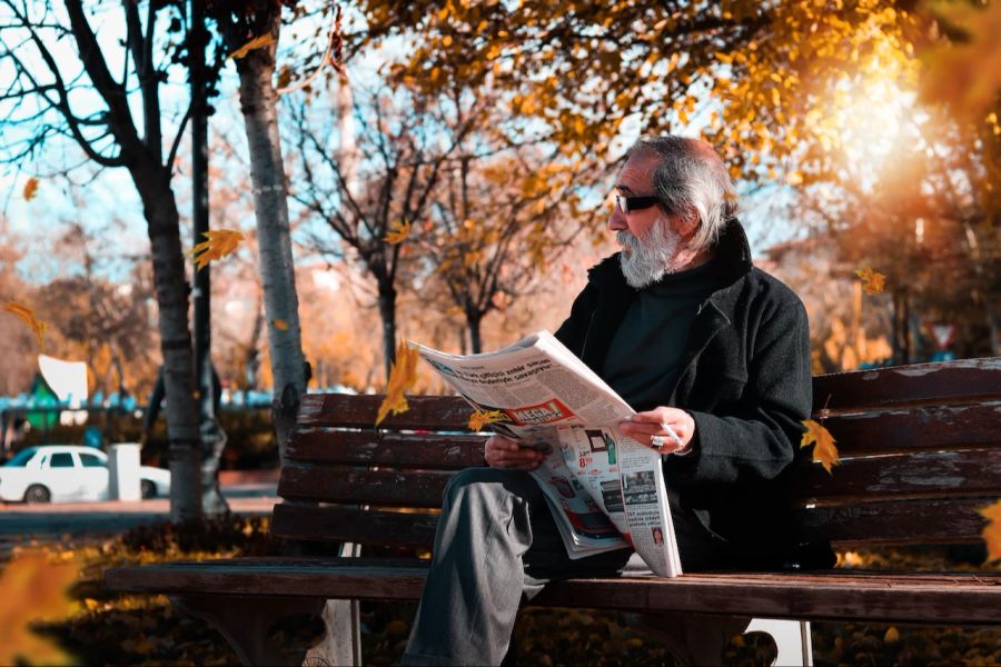 Mann Bank Zeitung Lesen draussen