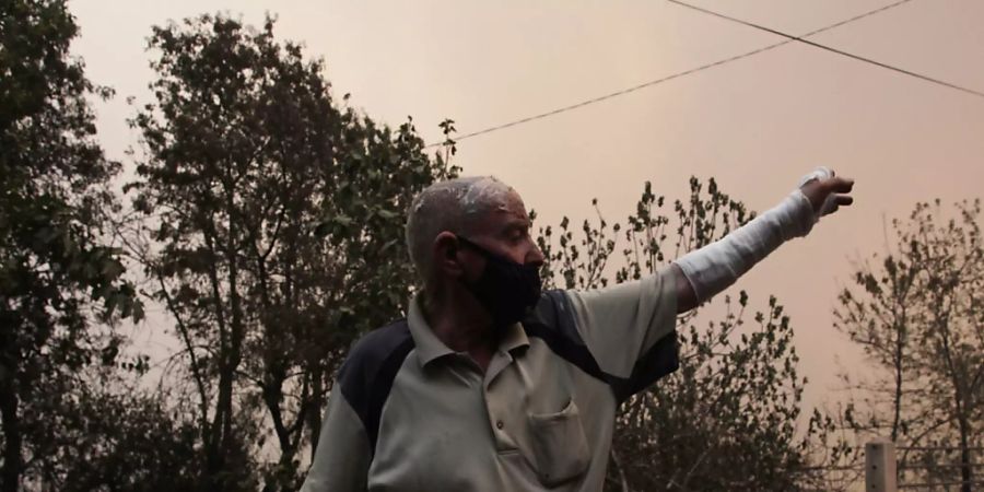 Ein Mann flieht aus einem Dorf in der Nähe von Tizi Ouzou, etwa 100 km östlich von Algier. Foto: Fateh Guidoum/AP/dpa