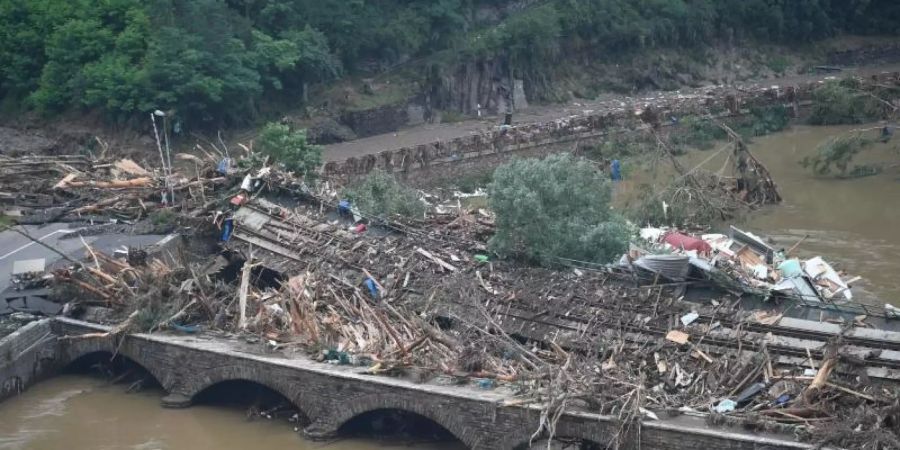 Eine Brücke nach Altenahr ist durch Schutt und eine Eisenbahnbrücke versperrt. Foto: Lino Mirgeler/dpa