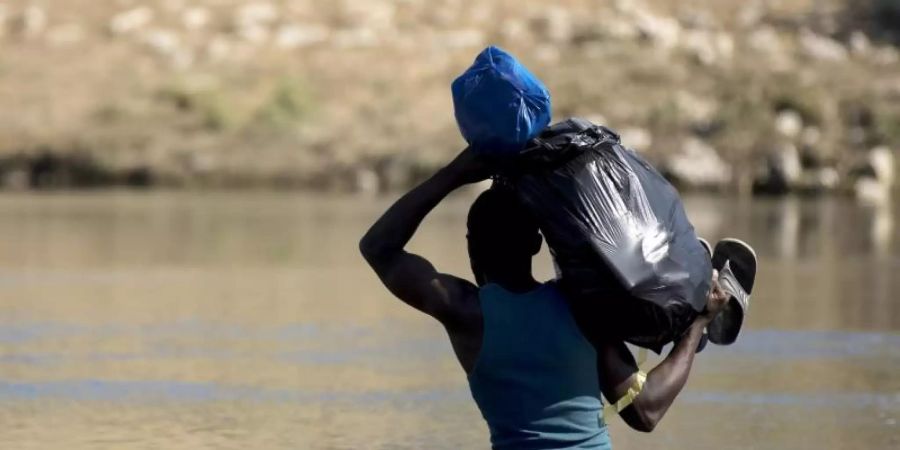 Ein haitianischer Migrant versucht den Fluss Rio Grande von Mexiko in die USA zu überqueren. Foto: Nick Wagner/XinHua/dpa