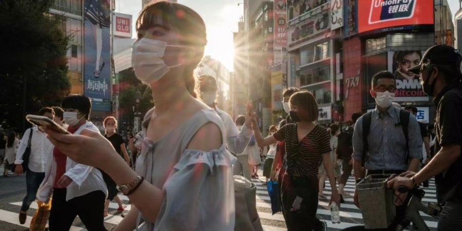 Passanten mit Atemschutzmasken in Tokio