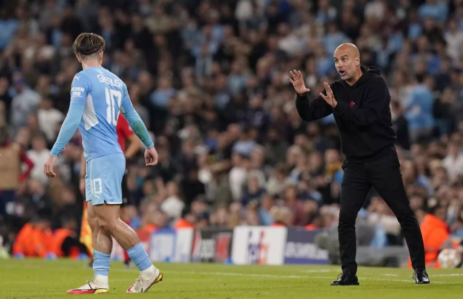 Trainer Pep Guardiola (r.) gibt Jack Grealish (l.) Anweisungen.