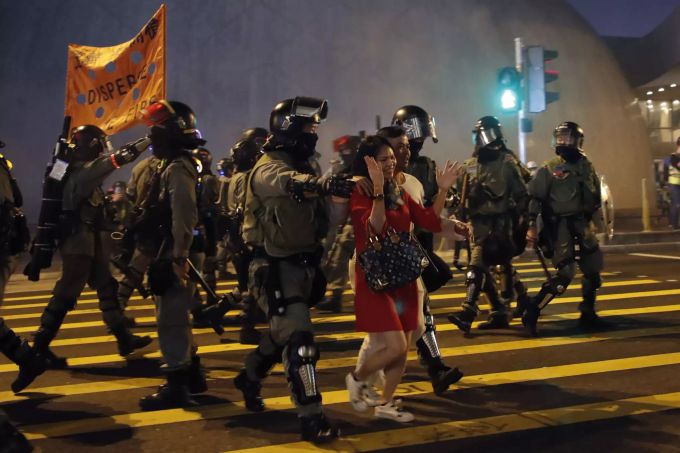Die Polizei führt Touristen über die Strasse während den Vorbereitungen gegen die Demonstranten. Hong Kong Protests